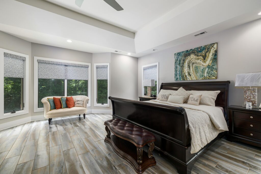 Sophisticated modern bedroom featuring luxurious furniture, large windows, and stylish decor with ample natural light.
